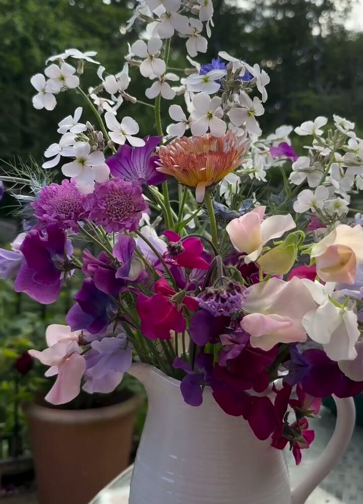 Jug of home-grown summer flowers on a garden table